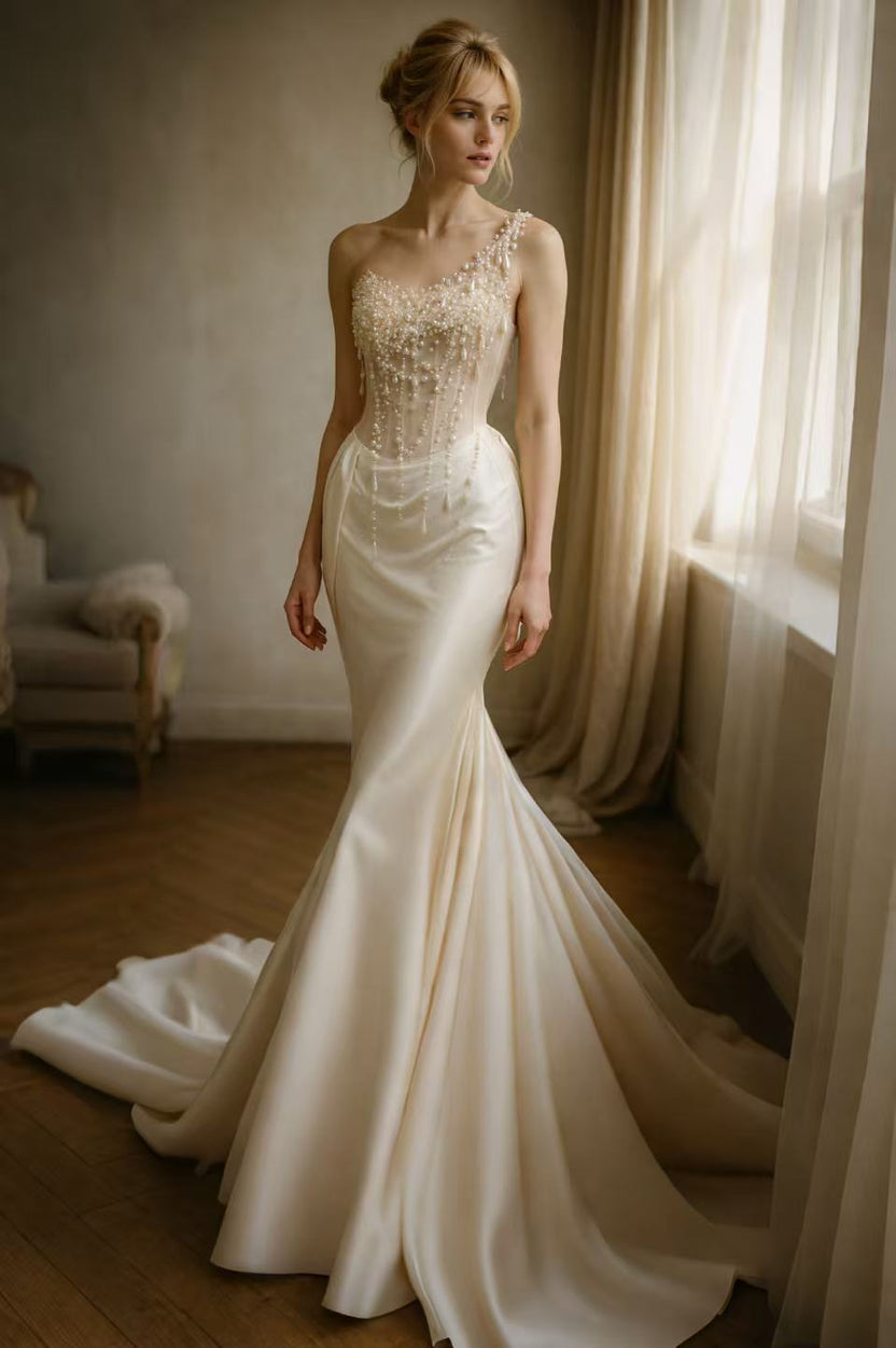 Champagne one-shoulder pearl fringe satin mermaid gown by muselula — front view
